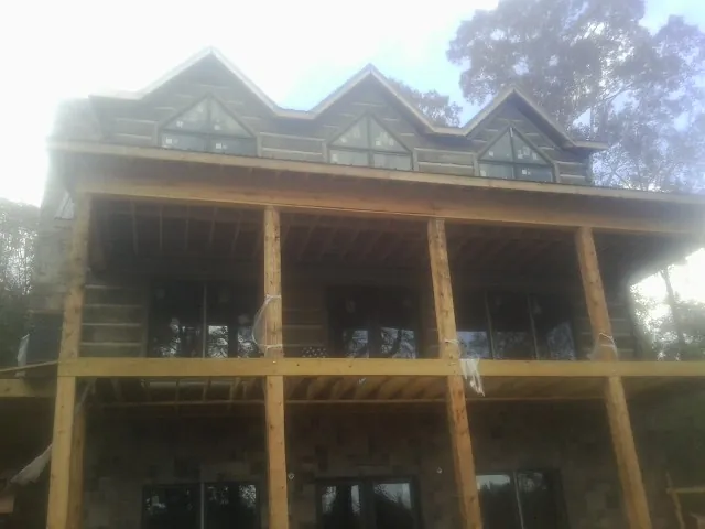 Dormers and porch framing on a large log home under construction — Roof Coating work by our crew in Tappahannock