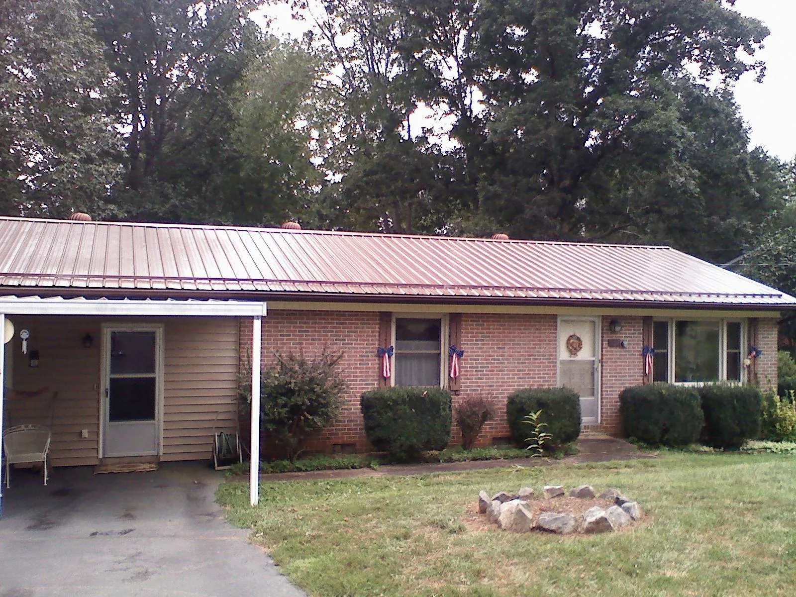 Bronze metal roof and carport on a brick ranch home — Roof Repair work by our crew in Tappahannock